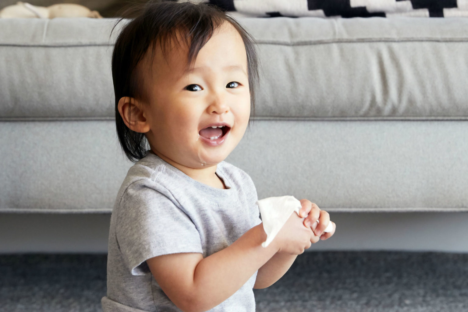 baby clutching a wet wipe