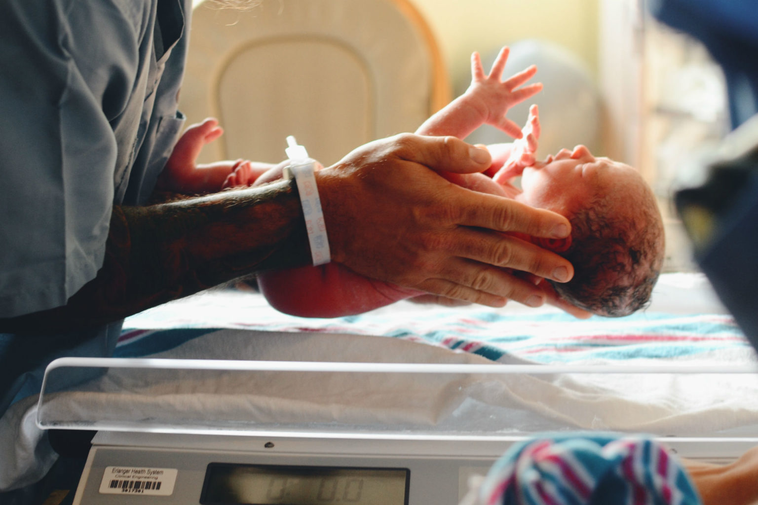 newborn baby being placed on a scale