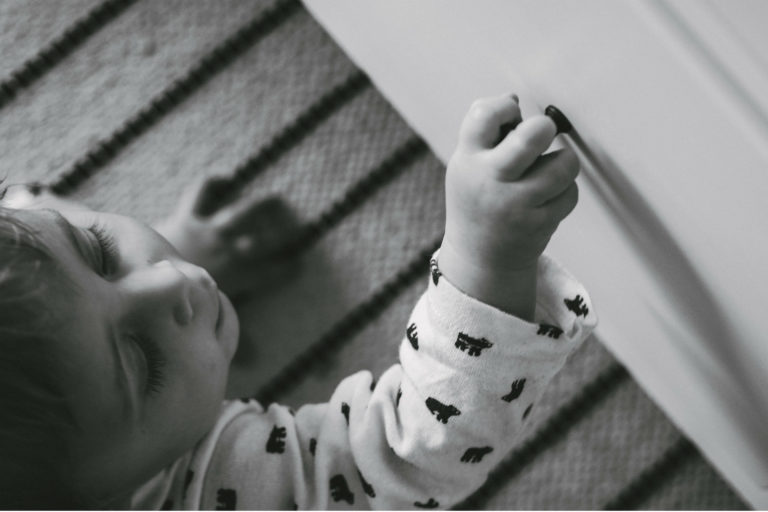 baby on the floor reaching for a drawer
