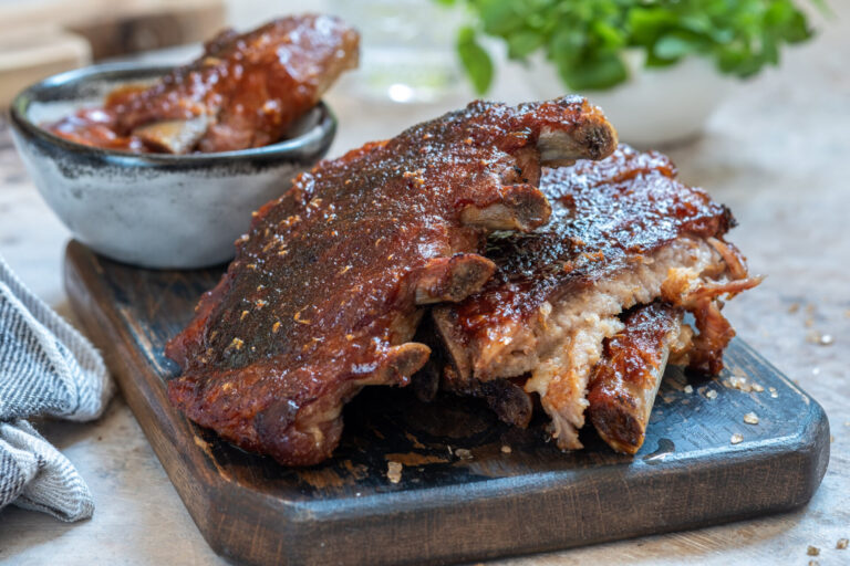 Slow cooker glazed ribs resting on a cutting board