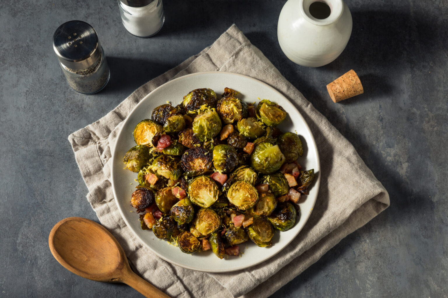 Cider-bacon Brussels sprouts with apples served in a white serving dish
