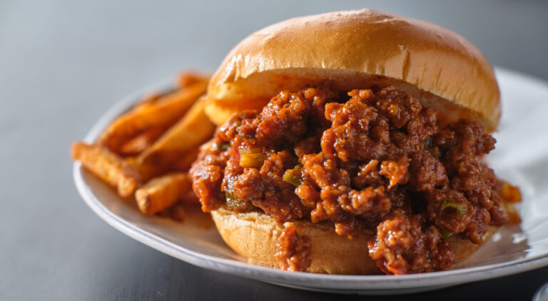 Vegan sloppy joes served with French fries on a white plate