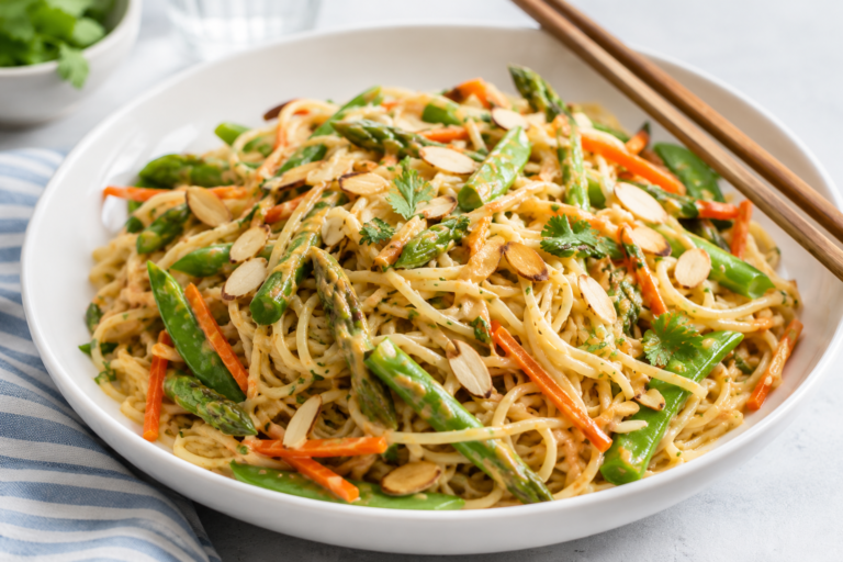 Cold almond noodle salad in a white dish with chopsticks