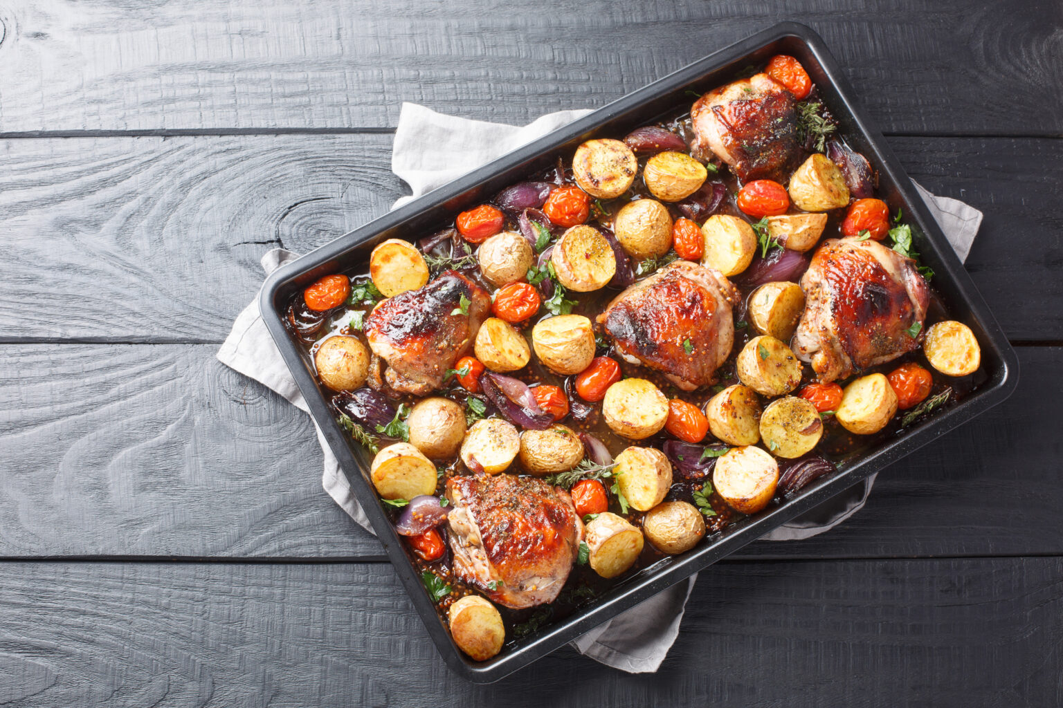 Herbed chicken tray bake on a dark countertop