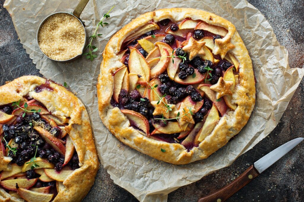 Berry-peach galette resting on parchment paper