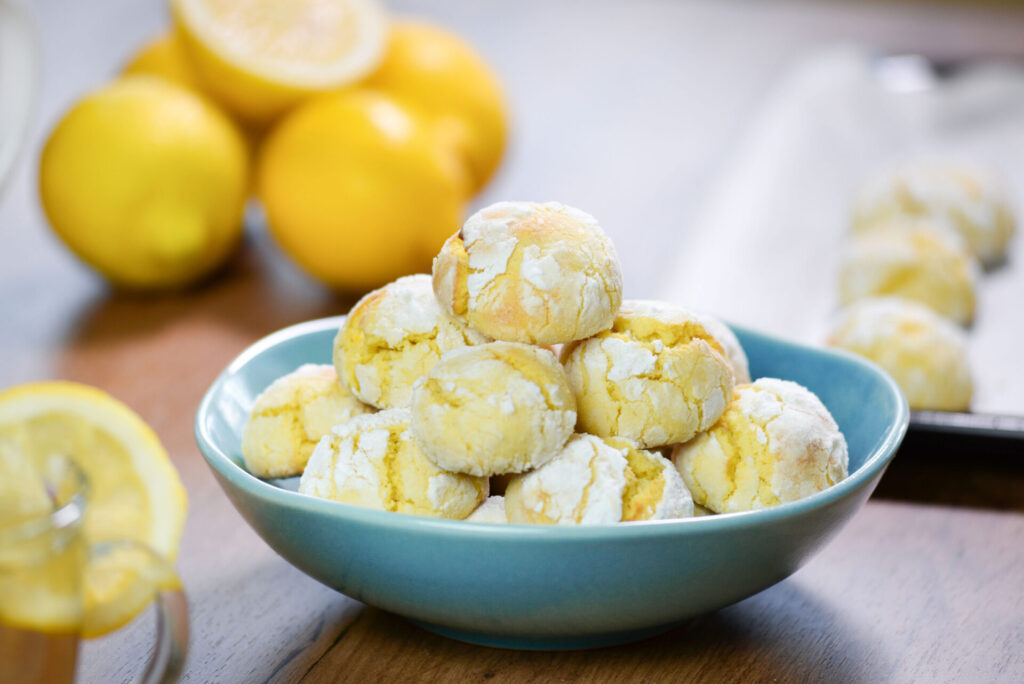 Chewy lemon crackle cookies in a turquoise bowl