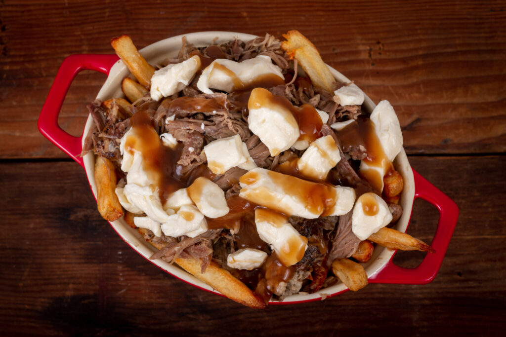 Pulled beef poutine in a red ceramic crock with handles