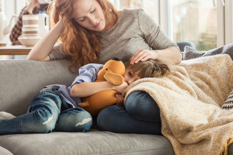 mother with son's head in her lap on the couch