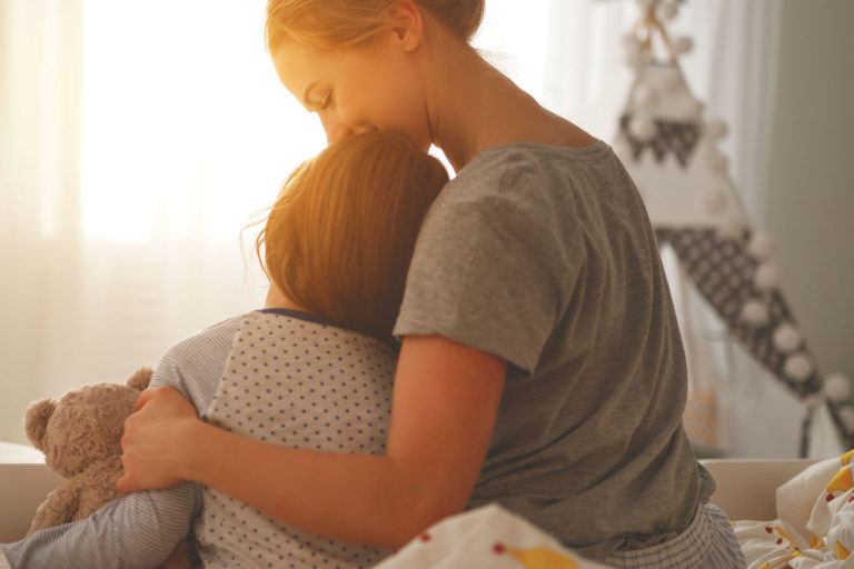 mother kisses son's forehead
