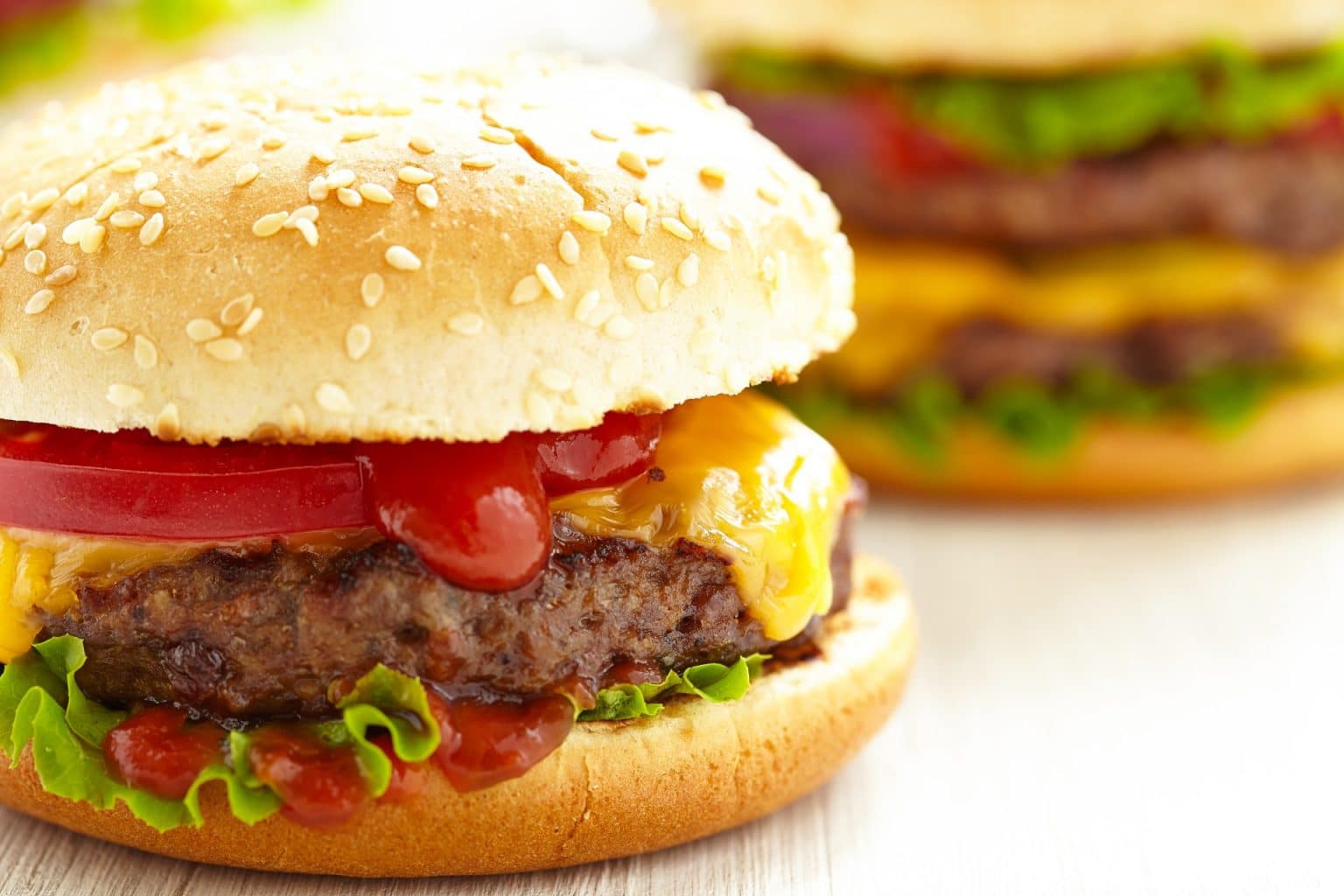 cheeseburgers with melty cheese on a white background