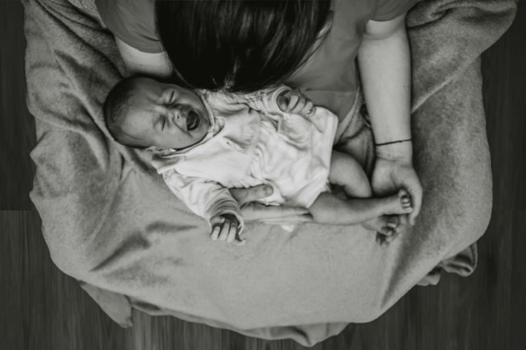 A fussy baby crying on mother's lap