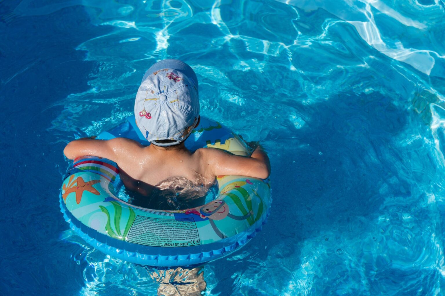 A little boy using an inflatable tube in a pool