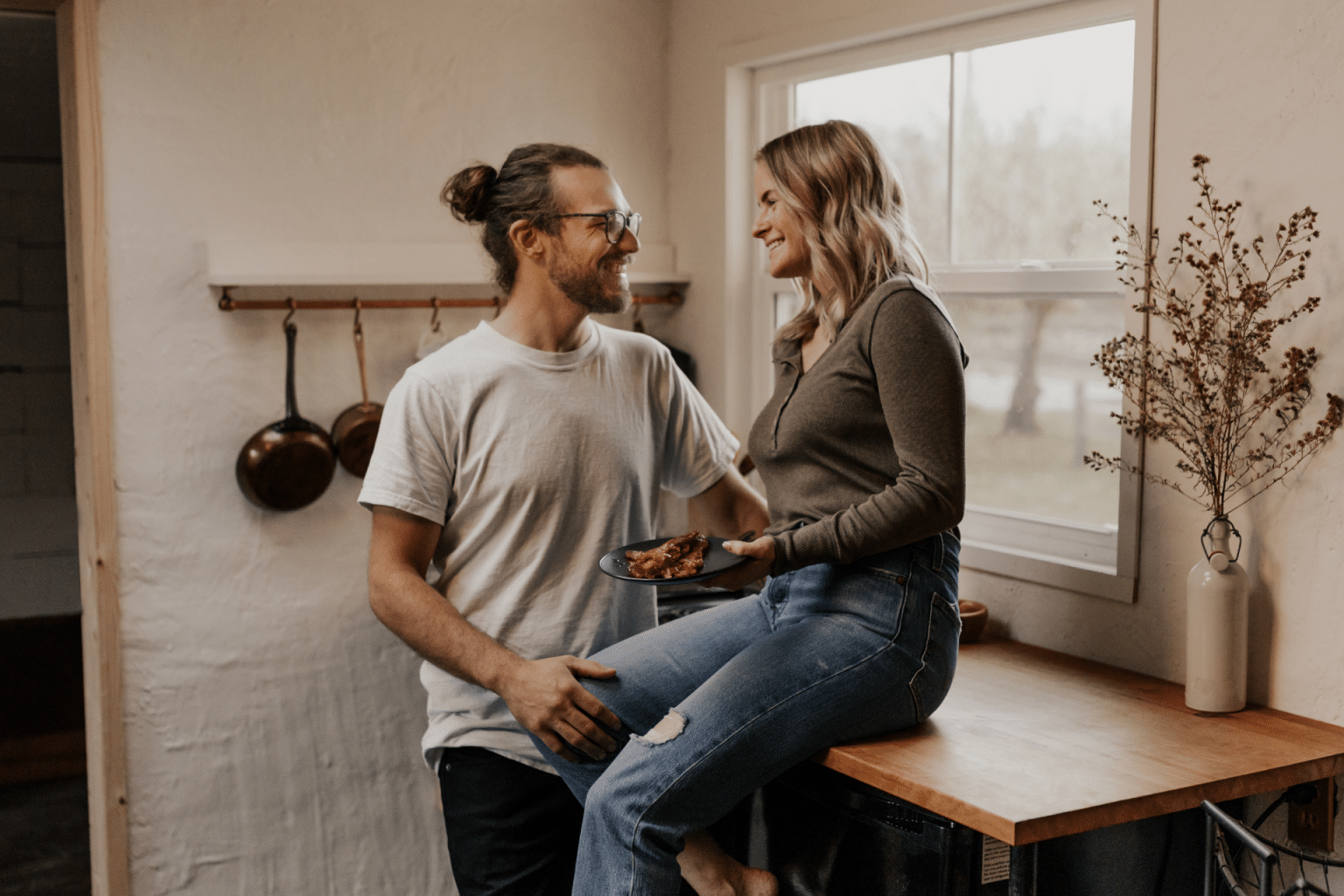 a couple in the kitchen flirting without kids around