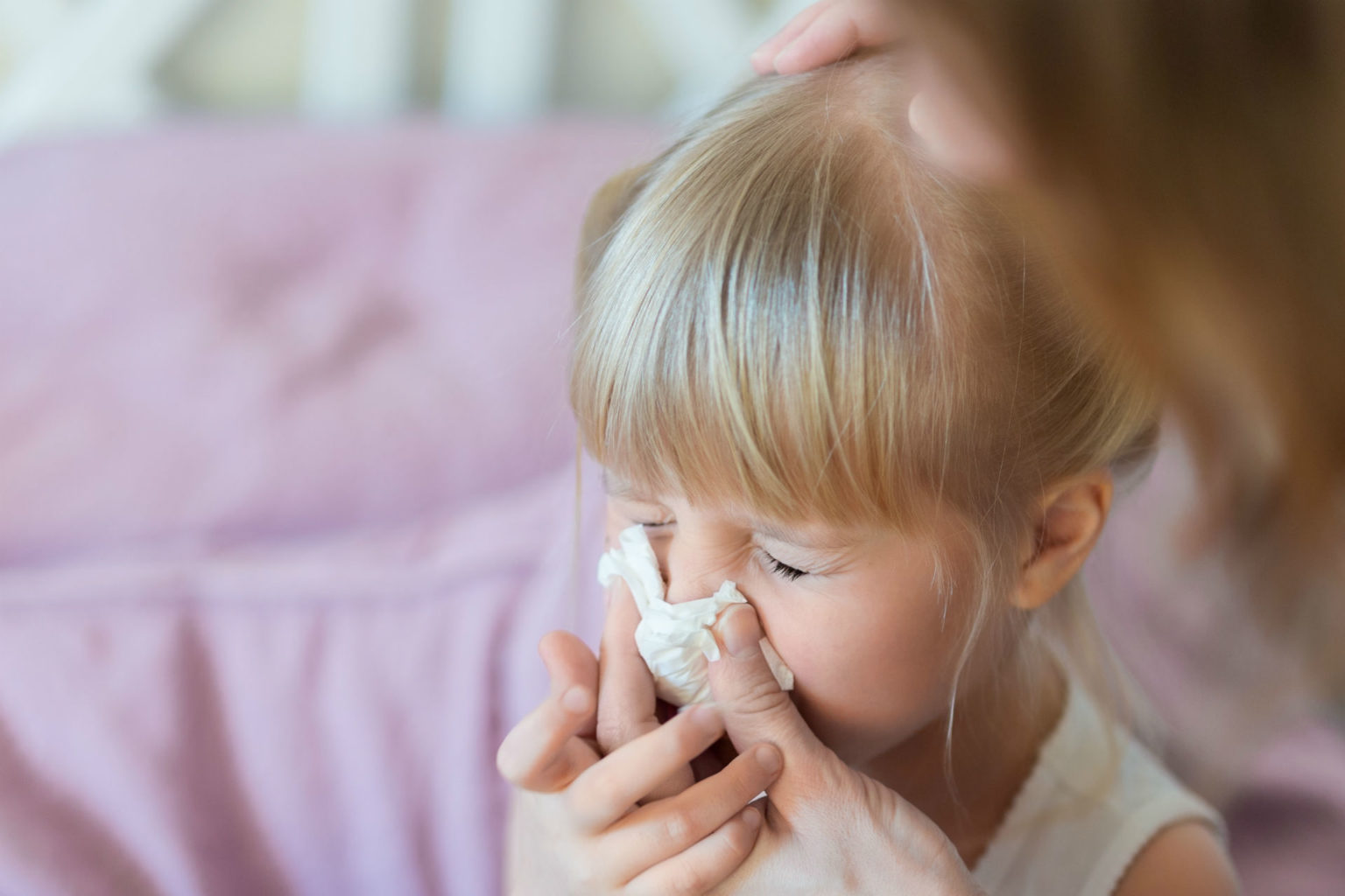 little girl with tissue to her nose