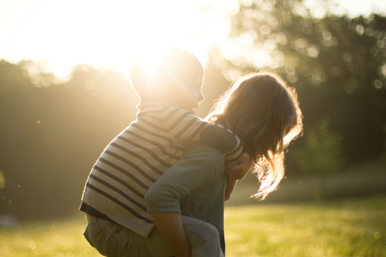 kid on mom's back in sunbeam