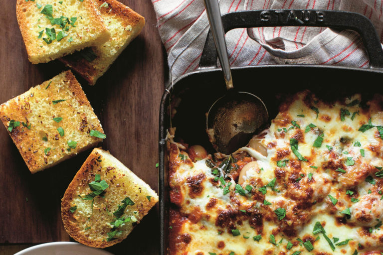 pan of baked beans with melted, stringy cheese on top