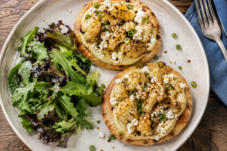 Roasted cauliflower and hummus flatbread pizzas on a white plate