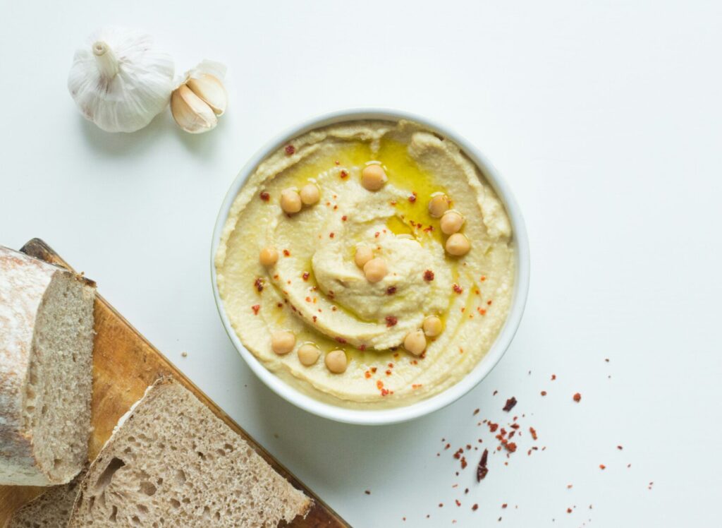 Easy homemade hummus made with chickpeas and garlic, in a white bowl