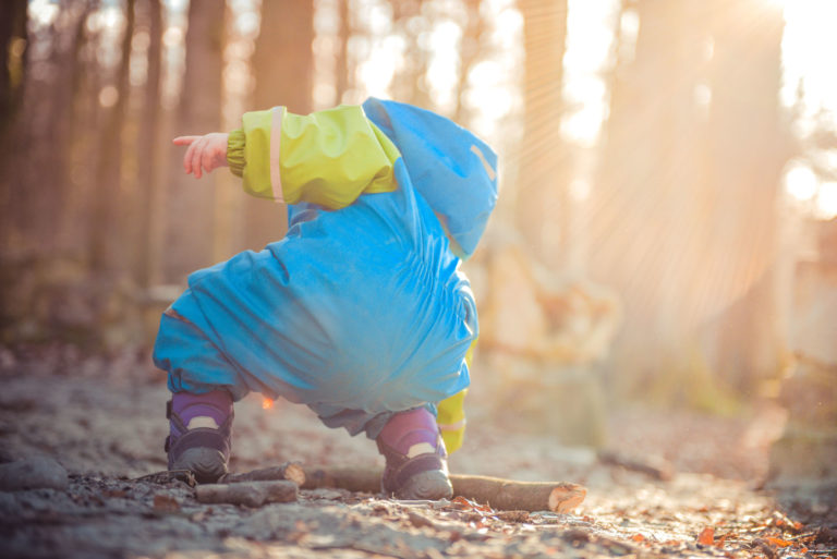 little boy picking up sticks