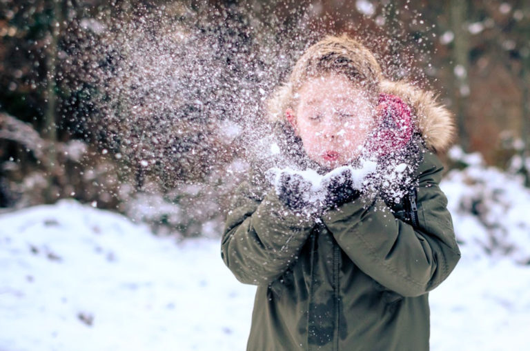 little boy blowing snow
