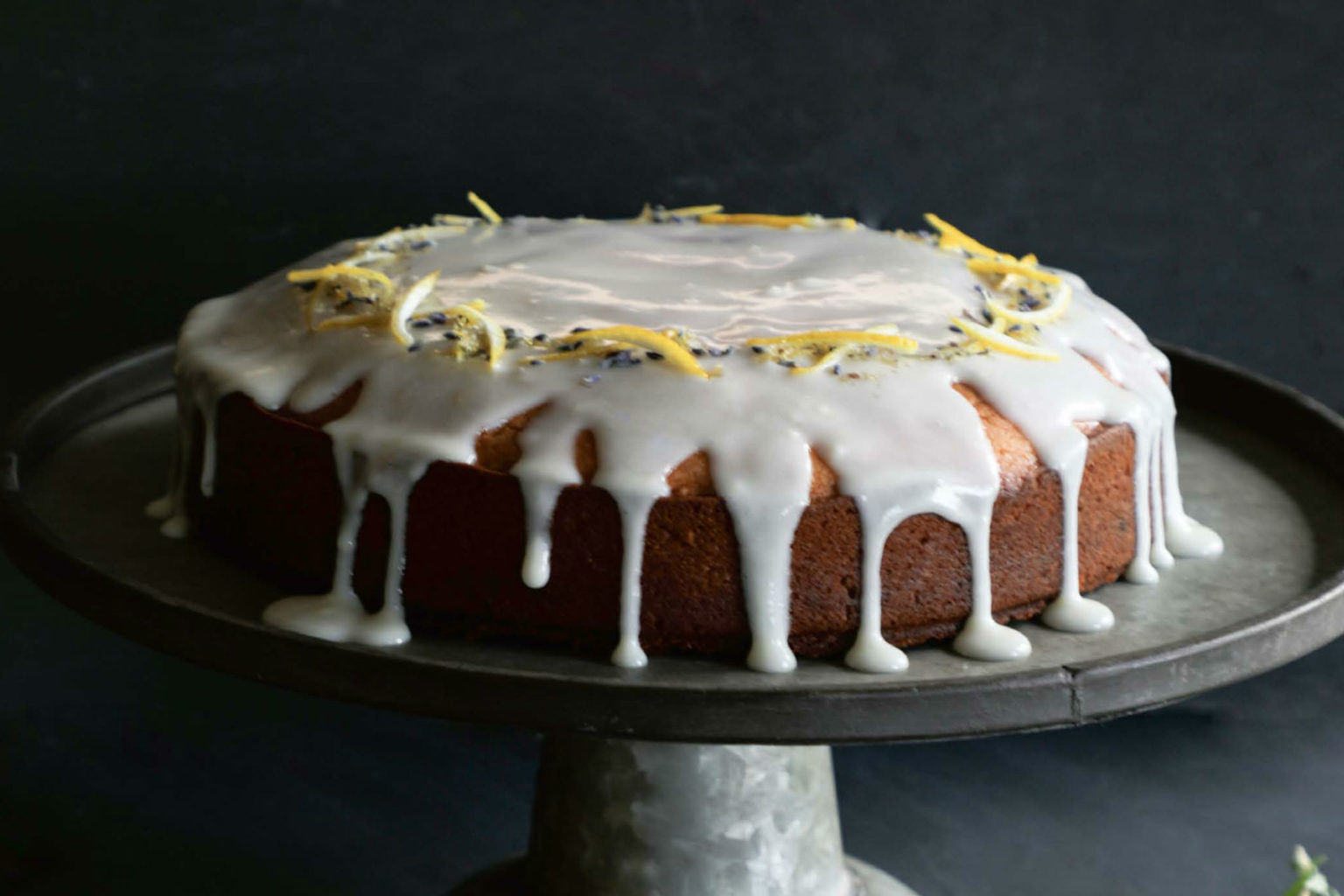 cake on a pedestal drizzled with icing