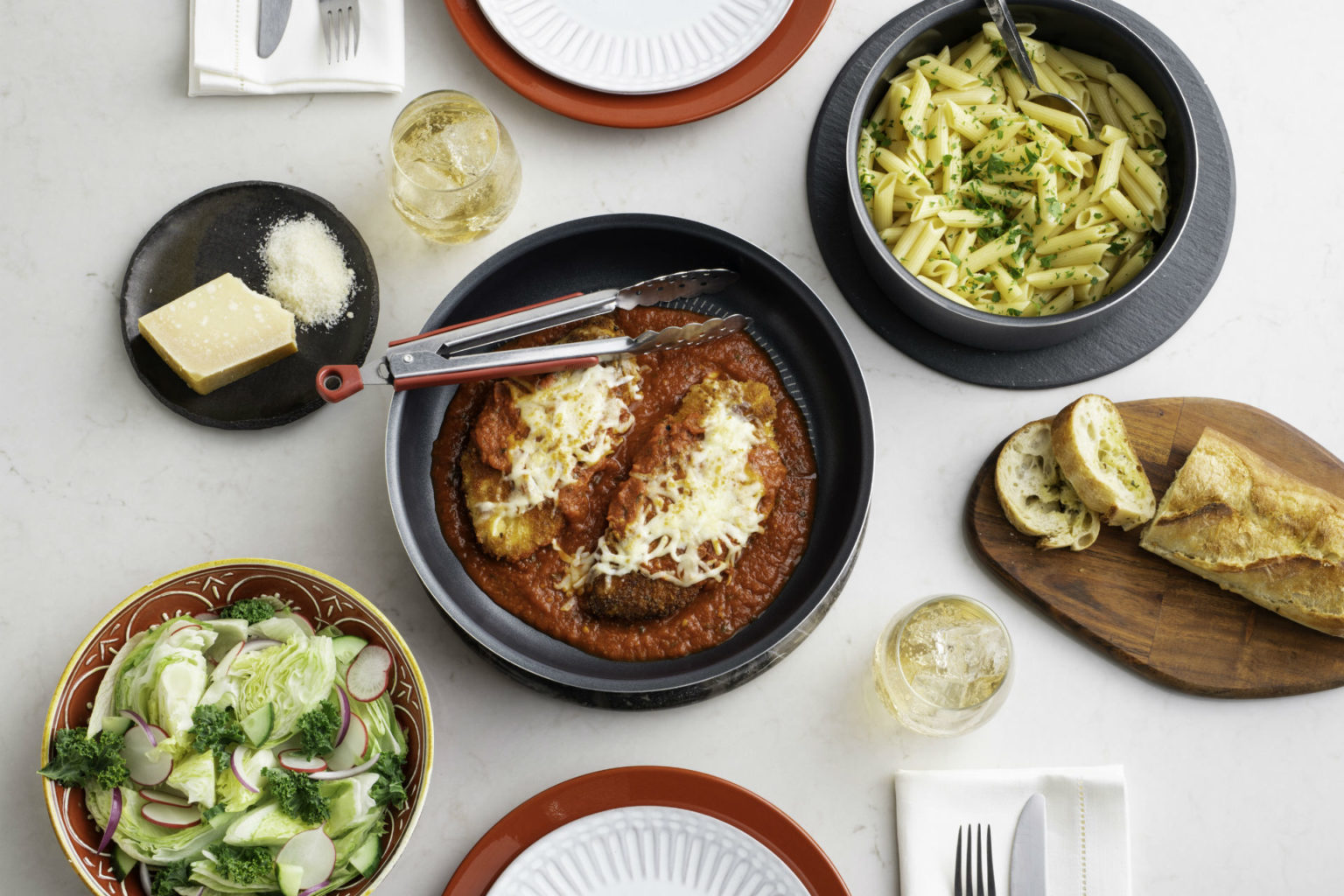 chicken parm on a plate with pasta and salad