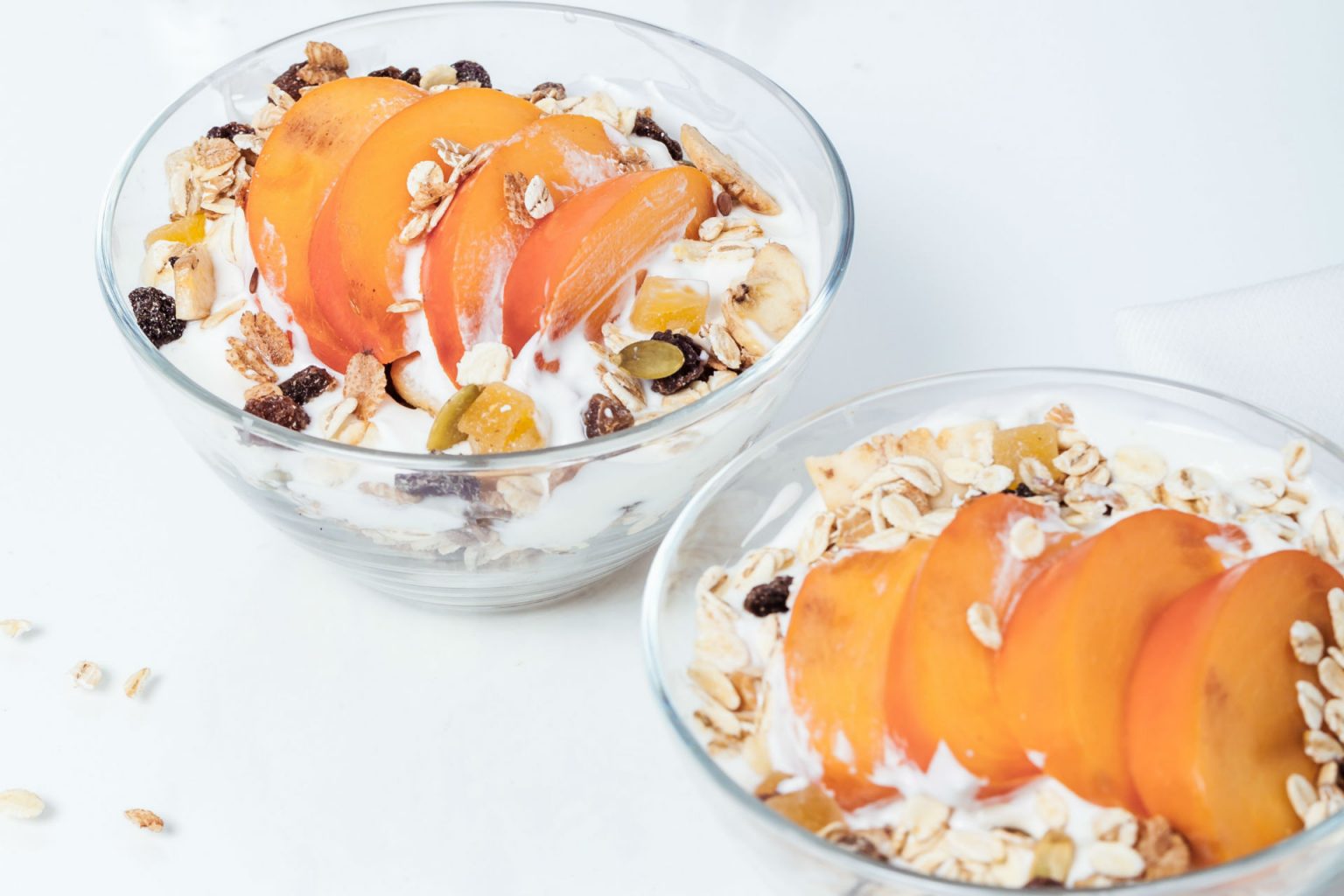 bowls of yogurt with granola and peaches