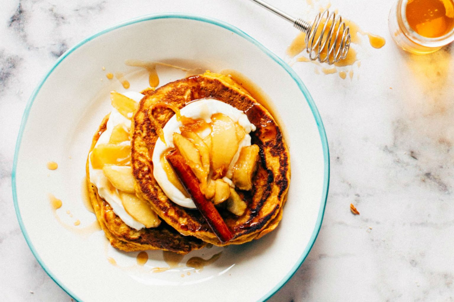 pancakes on a plate with apples and cinnamon