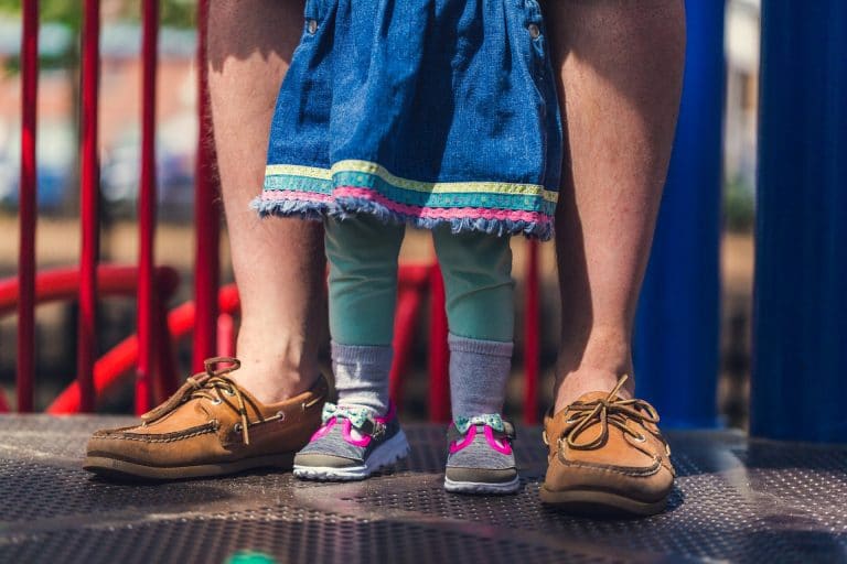 Child's feed inside her father's feet