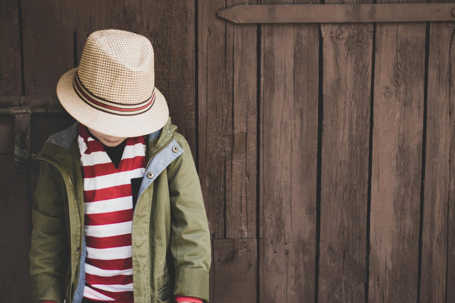 Book in a hat and striped shirt, looking down