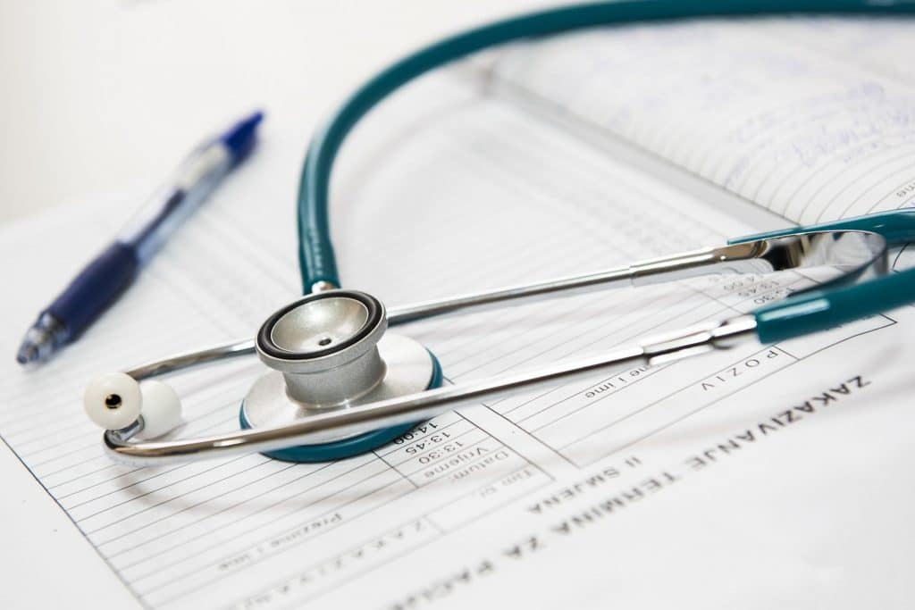 Stethoscope resting on a patient chart with a pen nearby