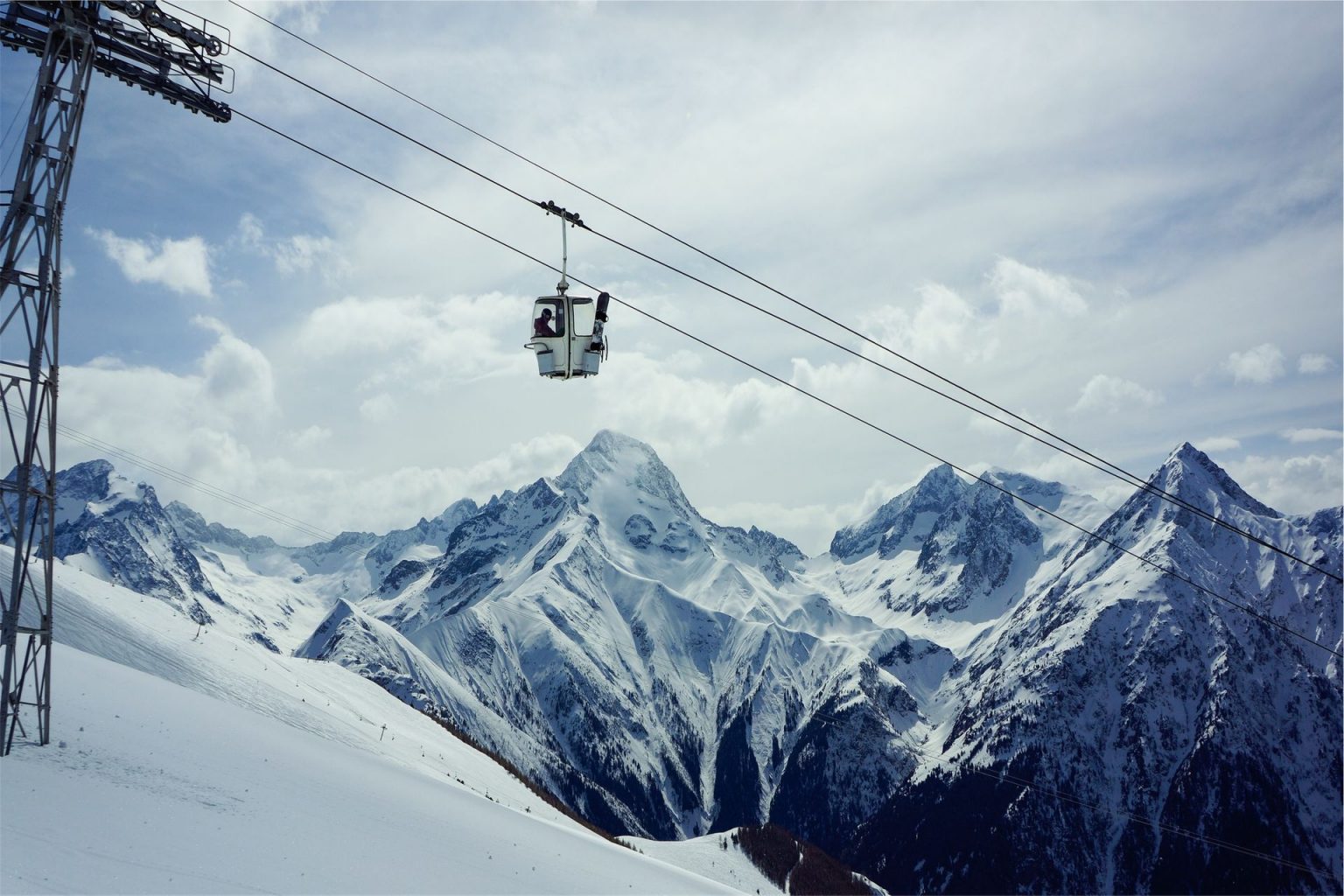 Ski lift in front of snow-capped mountain