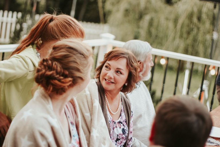 Woman sitting with older relatives and kids