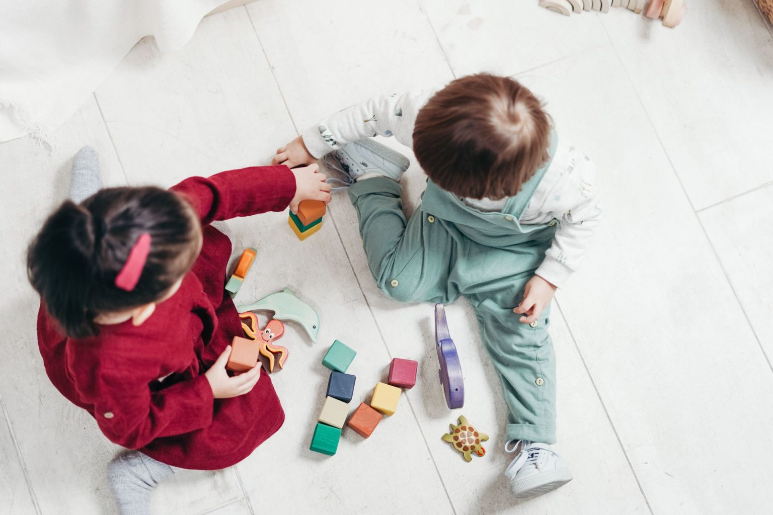 Overhead shot of two children playing with toys