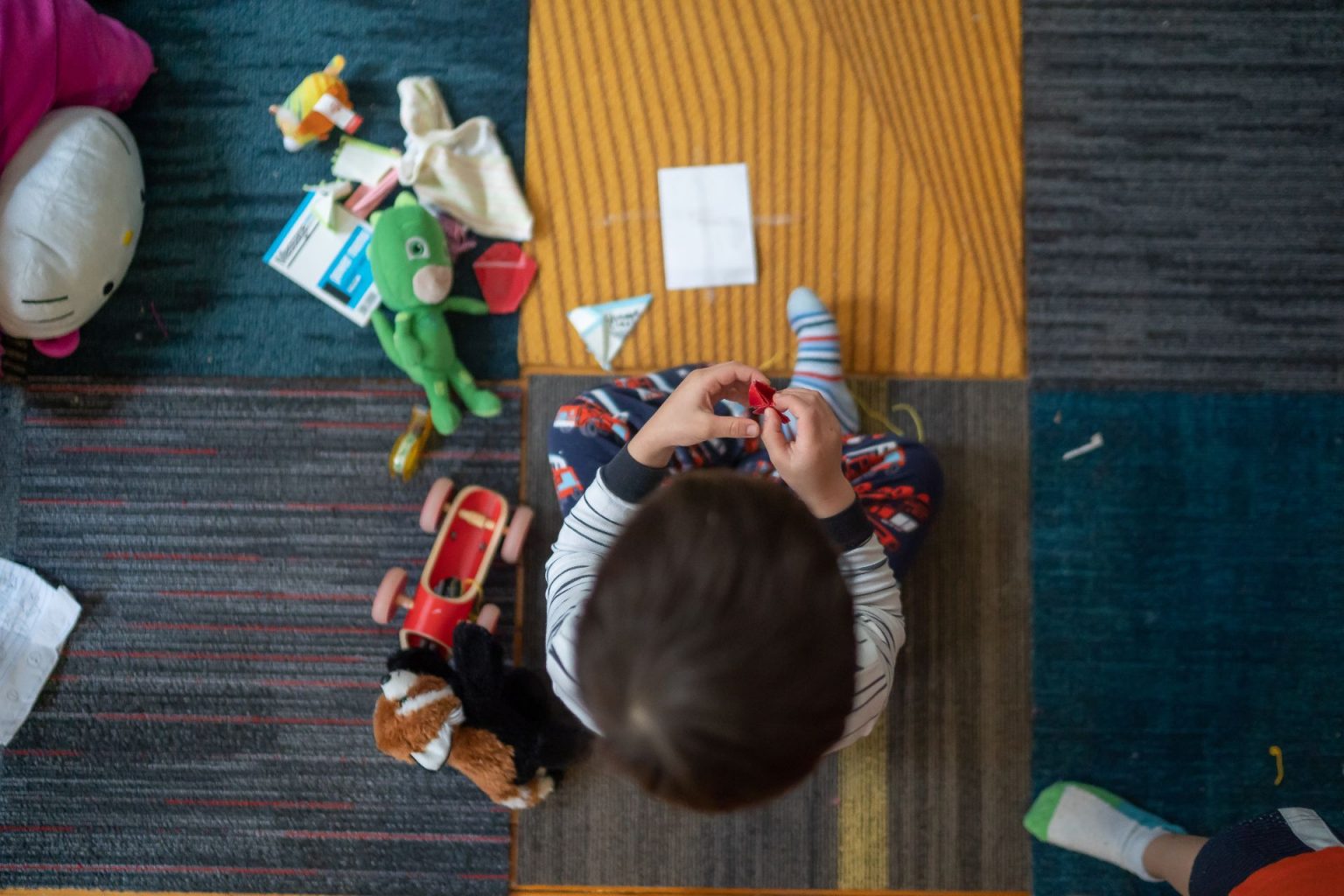 Aerial shot of kid sitting in pile of toys