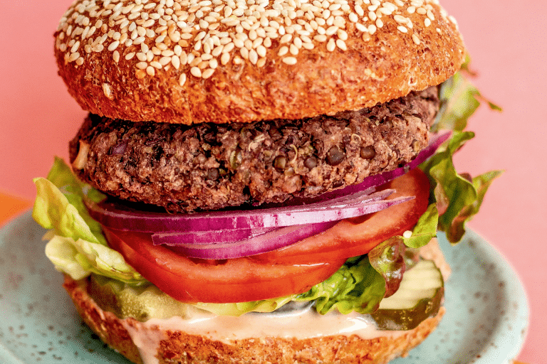 Lentil burger on a sesame seed bun with fresh veg