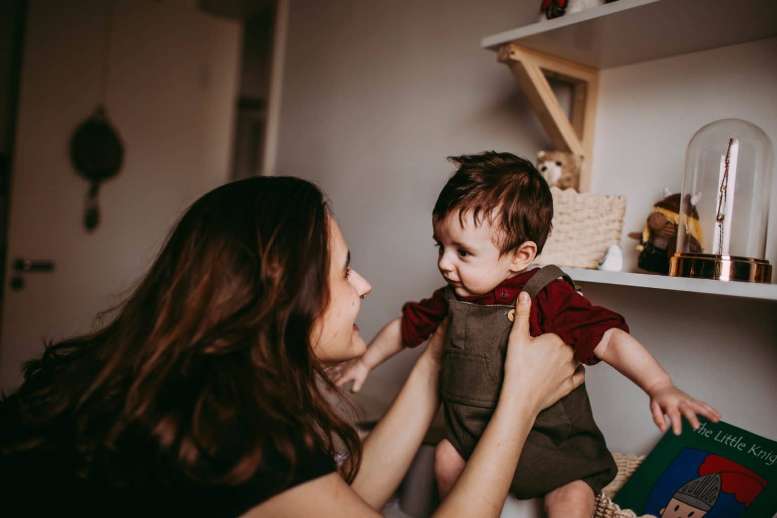 woman holding up her baby and looking happy