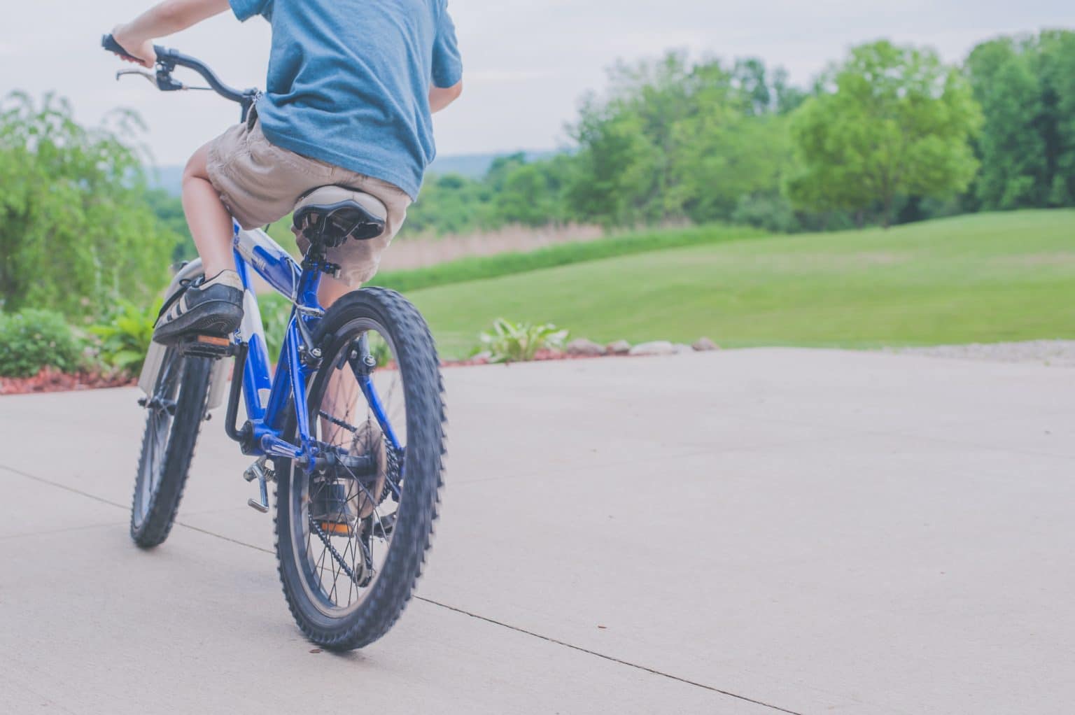 child riding a bike in a driveway