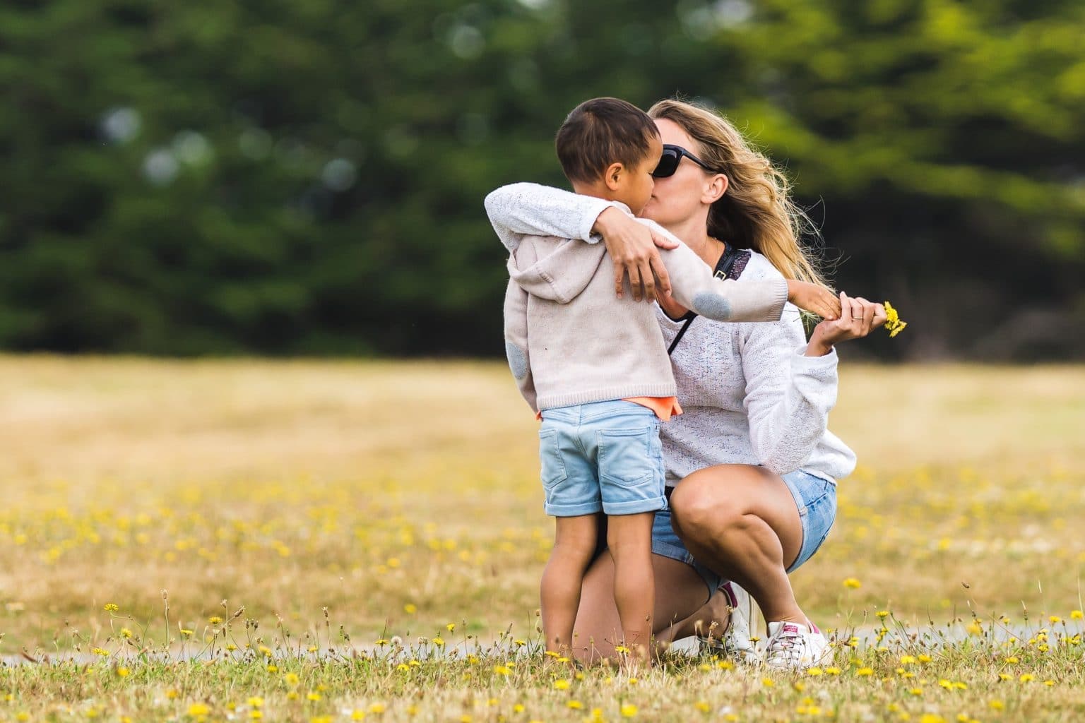 mother holding child in a field without anyone else around