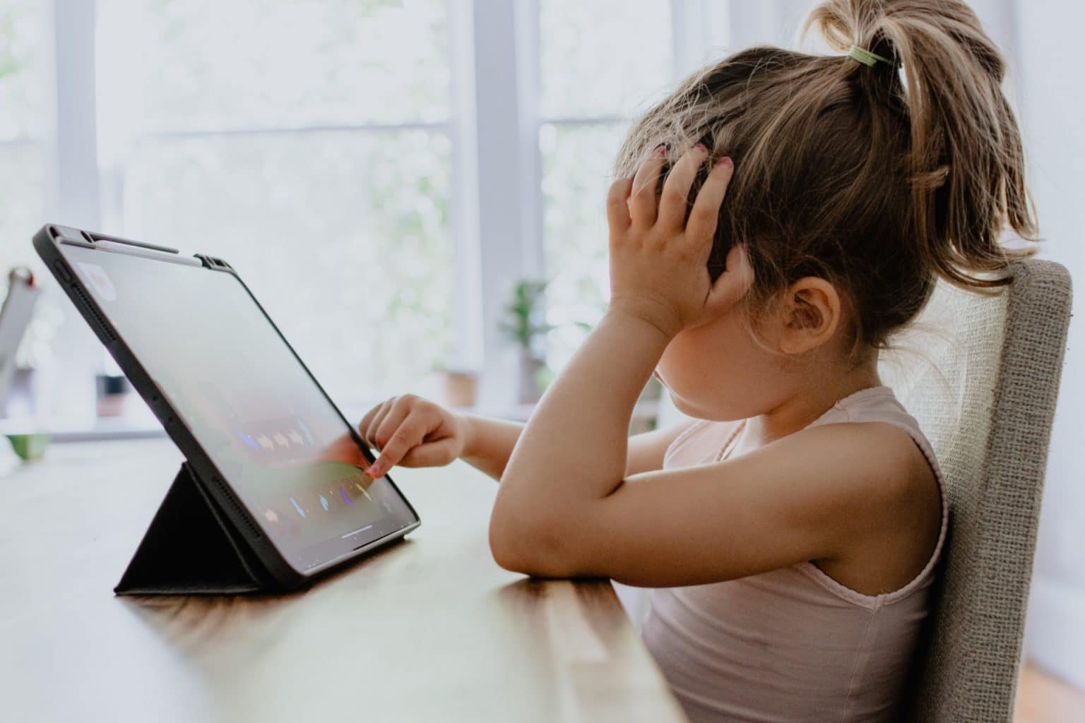 girl looking at a tablet during online school