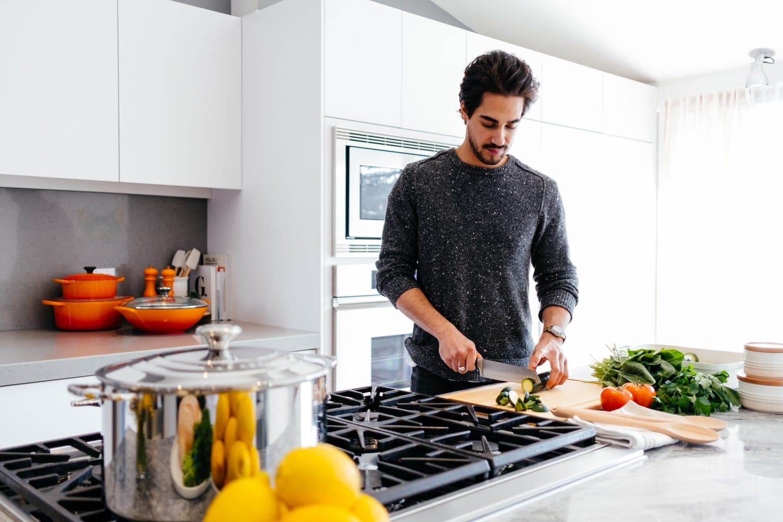 man chopping vegetables in a Le Creuset heavy kitchen