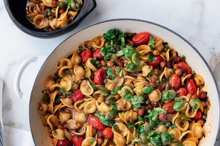 pan of puttanesca with tomatoes and fresh herbs
