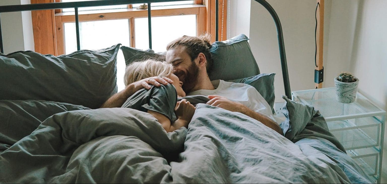 Couple lying in bed in daylight