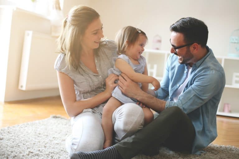 mother and father on the floor with their daughter