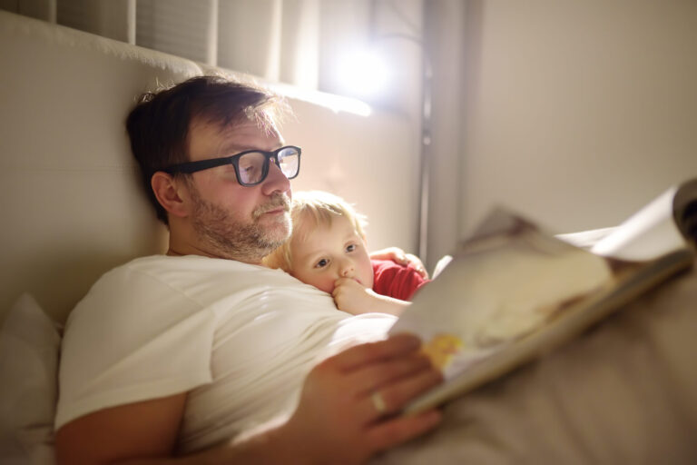 a man and a baby lying in bed