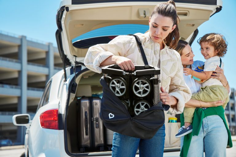 a woman putting luggage in the back of a car