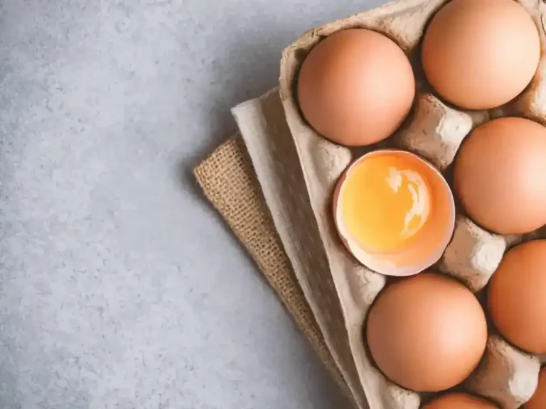 a carton of eggs with an egg yolk in it