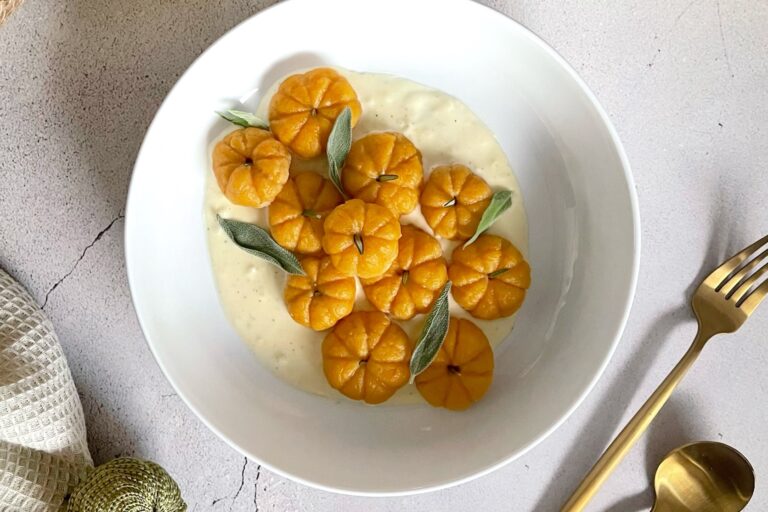 plate of pumpkin-shaped sweet potato gnocchi in a creamy sauce