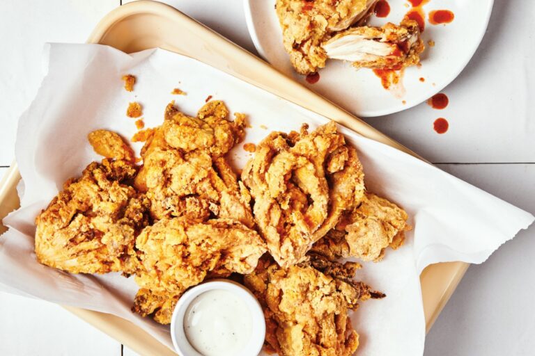 Baking sheet of battered fried oyster mushrooms that look like fried chicken