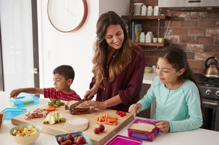 boy and girl helping to pack lunch with mom